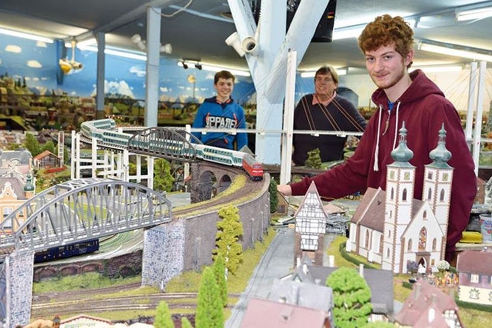Hier läuft’s rund: (V. r.) Lukas (16), Projektleiter Robert Klein und Harry (14) lassen die Modelleisenbahn anfahren.