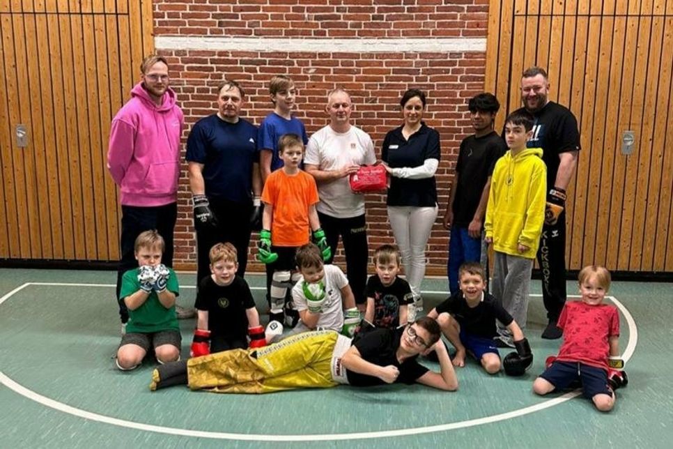 Ann-Christin Strehmel von der Alten Stadt-Apotheke übergibt eine Spende an die Kickboxer des TSV Neustadt.