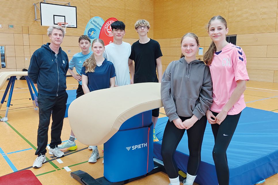 Die Schülerinnen und Schüler des Wahlpflichtkurses Sport der GGS-Strand Europaschule freuen sich mit ihrem Sportlehrer Ekkehard Rawohl über die neuen Gerätschäften.