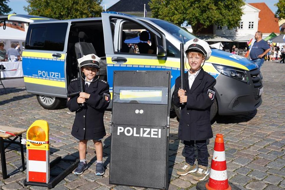 „Hier spricht die Polizei“: Leo und Lukas durften sich für einen Moment wie echte Polizisten fühlen und schon mal probieren, ob ihnen die Uniform gefällt.