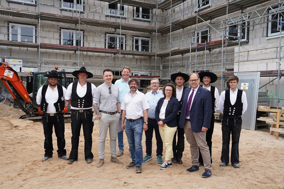 Die Zimmerleute der Firma Walter Hoffmann mit (v. lks.) David Krauß (Vorstand Baugenossenschaft), Geschäftsführer der Zimmerei Hoffmann Ralf Hoffmann, Martin Spieß (Architekt), Christoph Mehrpahl, Melanie Levingstone (Aufsichtsratsvorsitzende) und Bürgermeister Mirko Spieckermann.