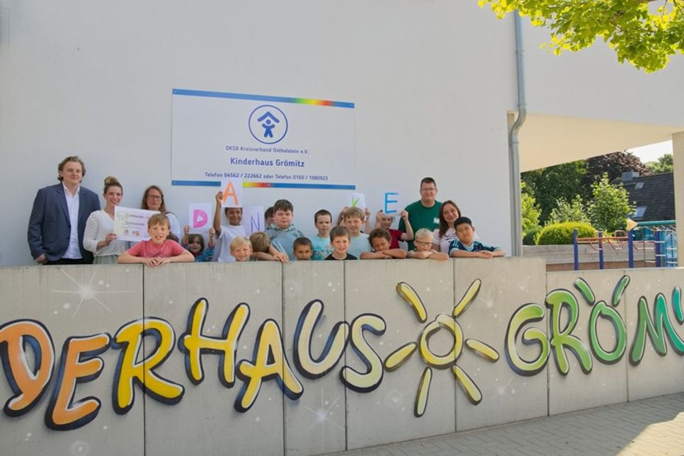 Julius Simon von Ahrens Ferienvermietung und Ahrens Immobilien sowie Büroleiterin Jana Schulz überreichen den Spendenscheck in Höhe von 1.000 Euro an Kinderhausleiterin Janine Perk (hinten v. lks.). Foto: Ahrens