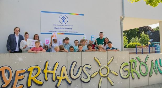 Julius Simon von Ahrens Ferienvermietung und Ahrens Immobilien sowie Büroleiterin Jana Schulz überreichen den Spendenscheck in Höhe von 1.000 Euro an Kinderhausleiterin Janine Perk (hinten v. lks.). Foto: Ahrens