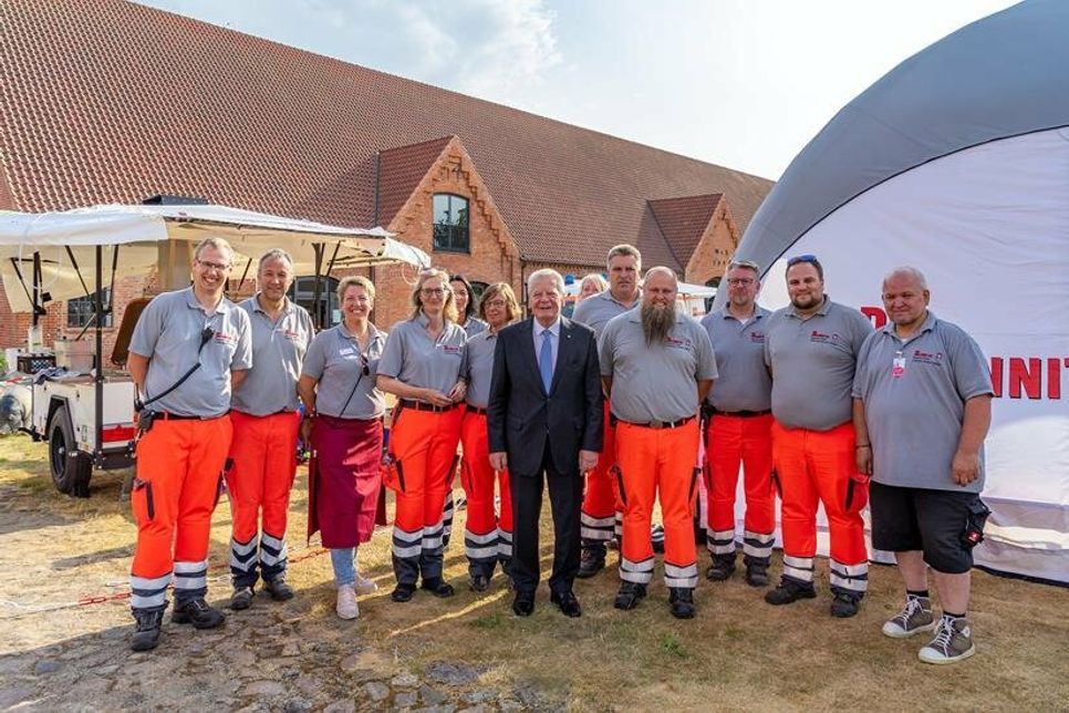 Die Logistikgruppe Lübeck der Johanniter-Unfall-Hilfe ist normalerweise bei Feuerwehreinsätzen und im Katastrophenschutz unterwegs. Auf der Hasselburg kochten sie für die Gäste und freuten sich über ein gemeinsames Foto mit Bundespräsident a.D. Joachim Gauck.