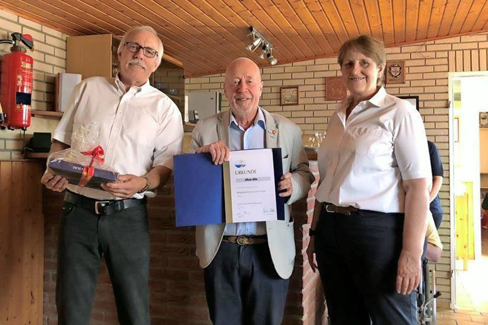 Die Vorsitzende der DLRG Neustadt Regina Block und der Technische Leiter Jochen Block bedankten sich bei Sönke Sela (Mitte) für die 60-jährige Treue zum Verein mit einer Ehrenurkunde und einem Präsent.