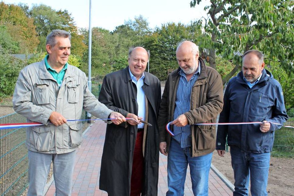 Kommissarischer Vorsitzender des Kleingartenvereins Edmund Laß, Erster Stadtrat Friedrich-Karl Kasten, Bauausschussvorsitzender Willy Heckel sowie Bauhof Abteilungsleiter Tiefbau Rüdiger Slawski (v. lks.) beim Durchtrennen das symbolische Band.