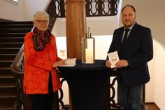 Kreispräsidentin Petra Kirner und Landrat Timo Gaarz halten symbolisch das Grundgesetz in der Hand.