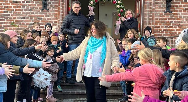 Die Schülerinnen und Schüler verabschieden sich mit viel Applaus von ihrer Schulsekretärin Susanne Musaeus. Schulleiter Lars Gallowsky und Konrektorin Christa Bellersen halten den Blumenbogen für das Spalier.