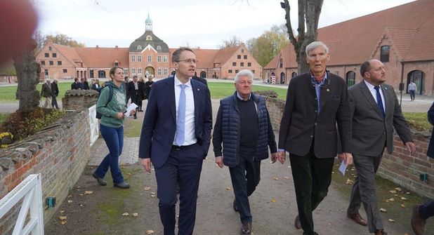 Ministerpräsident Daniel Günther (lks.), Dr. Constantin Stahlberg (2. v. re.) und Landrat Timo Gaarz (re.) beim Rundgang auf dem historischen Gutshof.