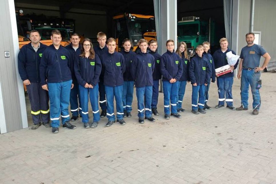 Jugendgruppenleiter Niklas Markmann bedankt sich im Namen der Jugendfeuerwehr mit einer Schachtel Pralinen und einem Blumenstrauß bei Wolfgang Reimer (re.), Inhaber vom Kfz Service Schönwalde.