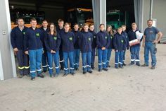 Jugendgruppenleiter Niklas Markmann bedankt sich im Namen der Jugendfeuerwehr mit einer Schachtel Pralinen und einem Blumenstrauß bei Wolfgang Reimer (re.), Inhaber vom Kfz Service Schönwalde.
