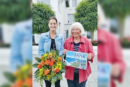Marketingleiterin Silke Szymoniak (links) ehrte Christa Buck für 80 Jahre Treue zu Niendorf/Ostsee vor der Burg Schröder, wo sie als kleines Kind die ersten Tage im Ostseebad verbrachte.