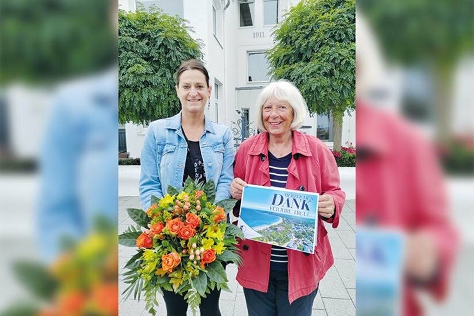 Marketingleiterin Silke Szymoniak (links) ehrte Christa Buck für 80 Jahre Treue zu Niendorf/Ostsee vor der Burg Schröder, wo sie als kleines Kind die ersten Tage im Ostseebad verbrachte.