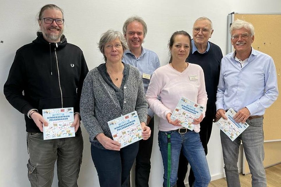 Mediengestalter Roland Woesner vom Balticum Verlag in Neustadt (lks.) bei der Übergabe der Festschrift an die Verantwortlichen des Kinderzentrums Pelzerhaken.