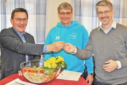 Jan Schüler (m.) freut sich über die gelungene Aktion, während Bürgermeister Thomas Haß (l.) das erste Los zieht und Patrick Bührsch überreicht.