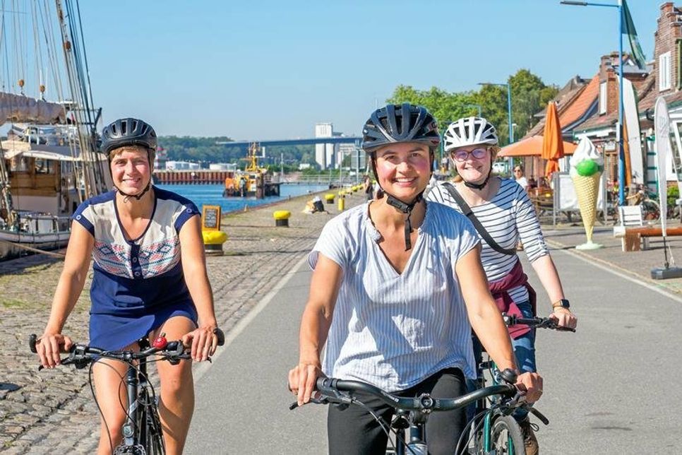 Treffpunkt um 14 Uhr beim Café Luna, Wellingdorf: Kira Schall, Rebecca Schoppe, Helen Boldt (v. l., hier beim Radeln durch Holtenau) laden mit dem NABU zum Müllsammeln am Schwentine-Ufer am Sonnabend, 16. September ein.