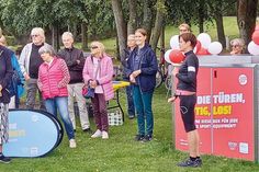 Interessierte verfolgen bei der Eröffnungsfeier die Vorstellung der Materialien. Anja Künzel vom Bereich „Schule und Sport“ (Hansestadt Lübeck) steht vor der neuen Sportbox, links neben ihr Karin Schulze Kersting, Vorsitzende von „Freizeit und Aktiv e.V.“.