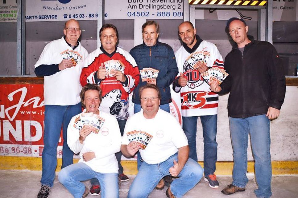 Dietmar Ebers (li.) und Britta und Michael Bertz (vorne) von FIETS e.V. sowie „Mr. Eishockey“ Kerry Goulet (2.v.li.), Hans Meyer (EHCT), Marcus Klupp und EHCT-Trainer David Rich mit den 125 Eislaufkarten, die über den „reporter“ verlost werden. (Foto: René Kleinschmidt)