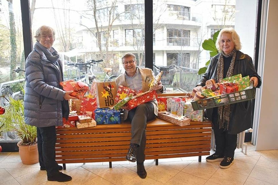 Timmendorfer Strands Bürgermeister Sven Partheil-Böhnke bei der Übergabe der Weihnachtsgeschenke vom „Rathaus-Wunschbaum“ an Barbara Bergmann („Kinderherz e.V.“, links) und Christine Gebauer („Sternenbrücke“).