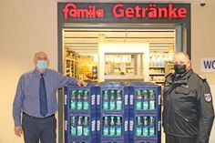Hans-Joachim Hamer und Eckard Rau vor dem Eingang zum famila-Getränkemarkt mit einer Muster-Getränkepalette.