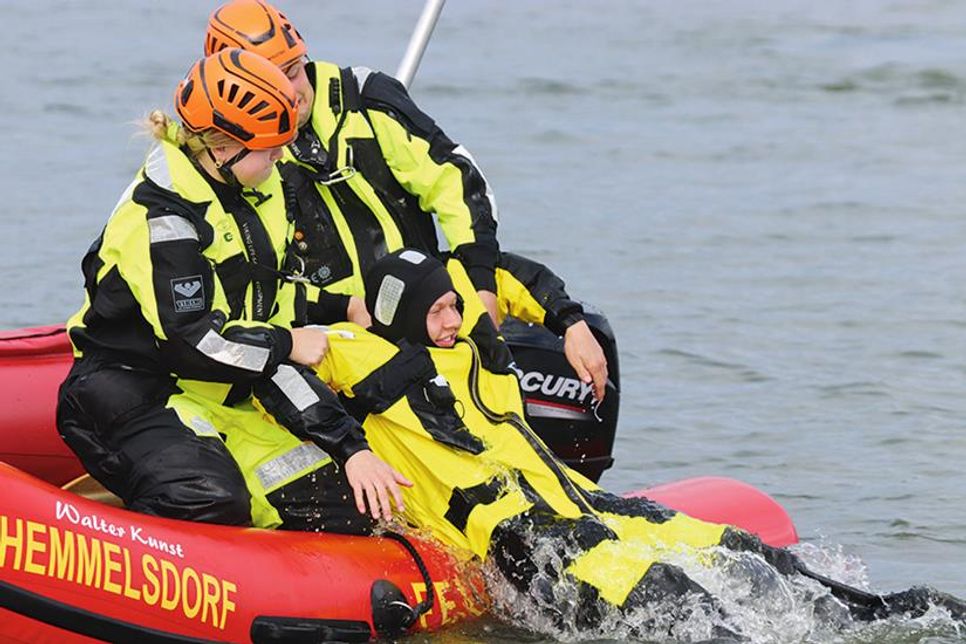 Eine Person wird mit Schwung ins Boot gezogen.