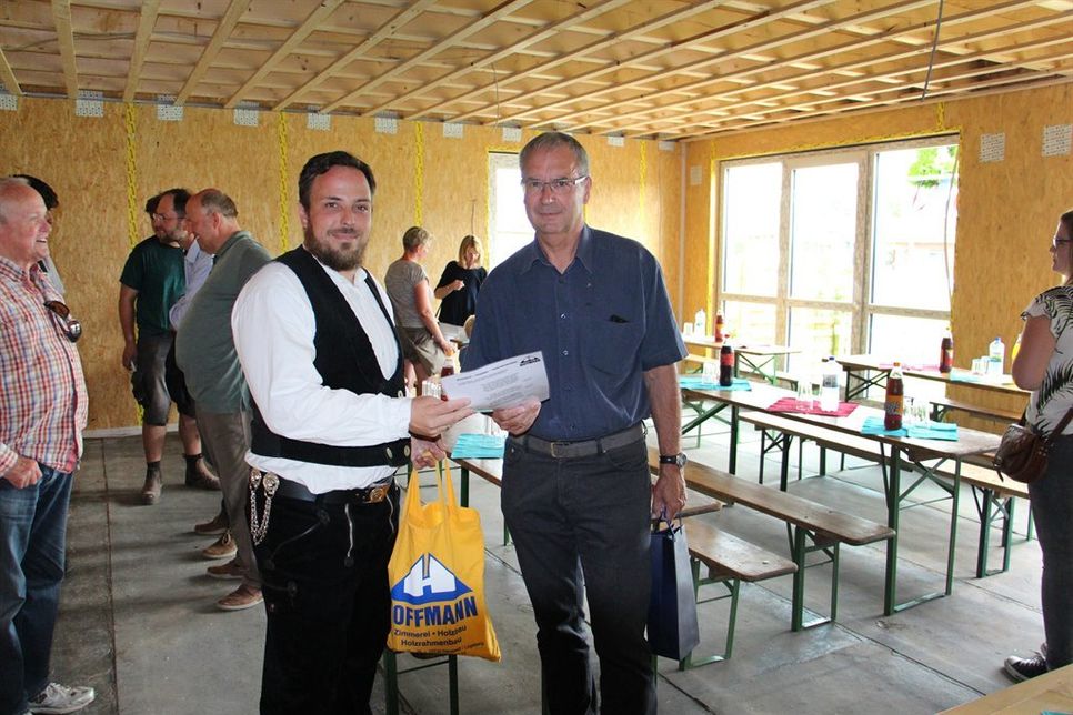 Zimmerermeister Christian Flägel überreichte den Richtspruch an Bürgermeister Hans-Peter Zink (re.).