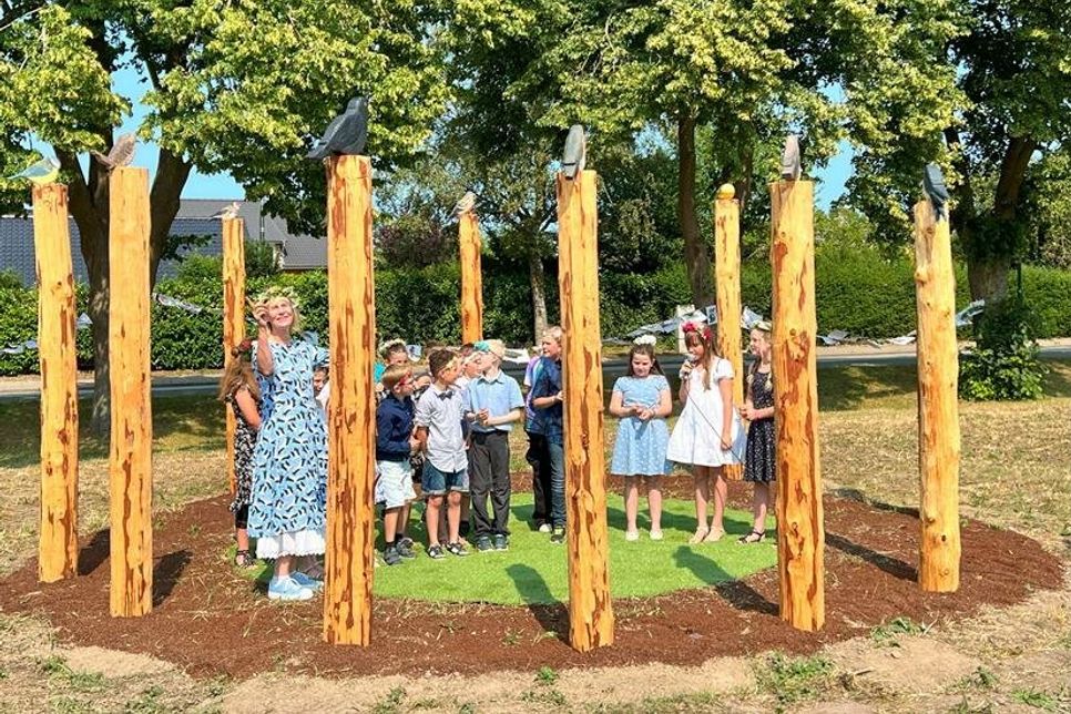 Klassenlehrerin Antje Wilkening und die jungen Künstlerinnen und Künstler bei der Einweihung der Vogeluhr.