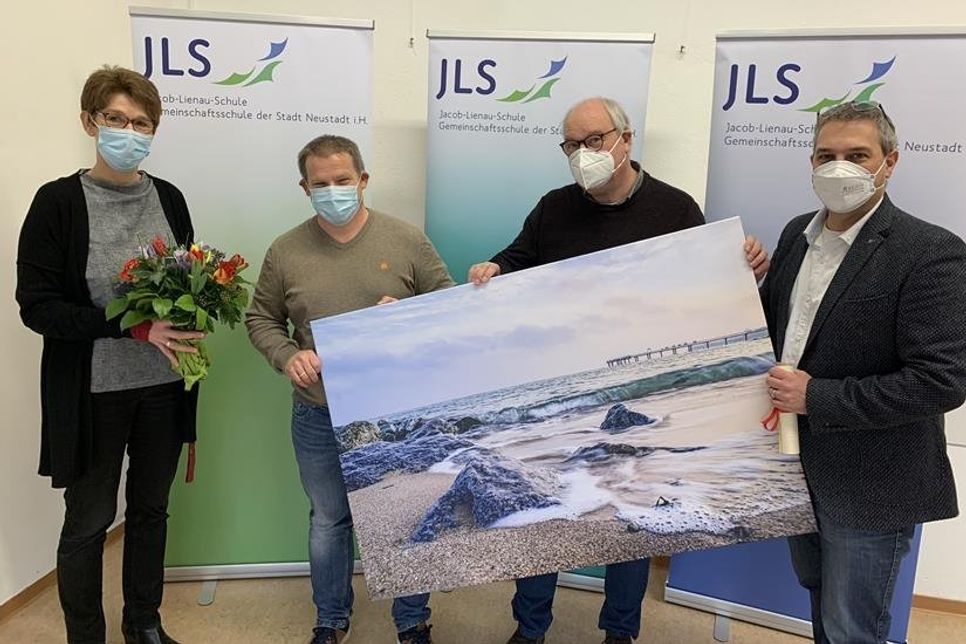Ein Bild von der Ostsee (fotografiert von der Neustädterin Finja Petersen) für das neue Büro. Margret Tamkus-Kattoll (lks.), Rolf Bohl (2. v. re.) und Andreas Beer (re.) verabschieden Werner Hendricks (2. v. lks.).