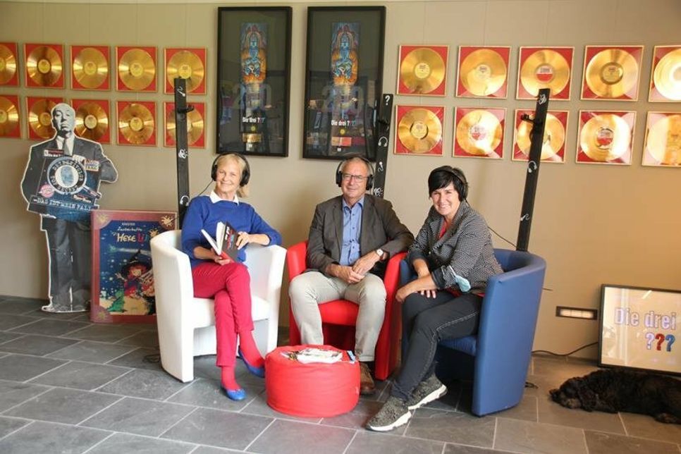 Hörspielproduzentin Heikedine Körting, Bürgermeister Hans-Peter Zink und Initiatorin Sandra Keck (v. lks.) bei einer kleinen Verschnaufpause in der Sitzecke am Eröffnungstag - natürlich mit Hörspiel auf den Ohren.