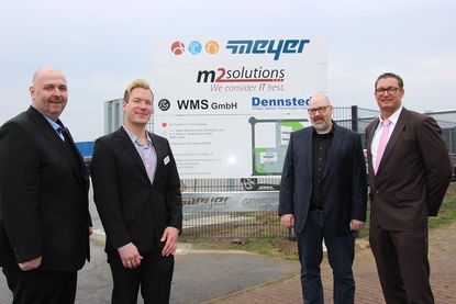 Reiner Matthiesen, Lukas Stockmann, Mirko Müller und Nils Meyer vor dem Schild des Gewerbeparks Meyer.