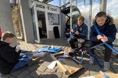 Hand in Hand für die Zukunft: Drei am Projekt beteiligte Jugendliche bauen vor dem Zuhörkiosk Mobiliar für die Ideenwerkstatt zusammen, die künftig hier ihre Tür öffnet.