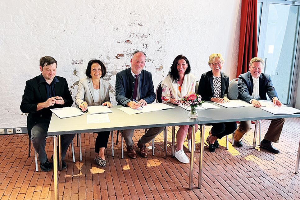 Jakob Sperrle (Stadtarchivar Eutin, von links), Anja Sierks-Pfaff (Ostholstein-Museum und Eutiner Landesbibliothek), Björn Demmin (Landrat Kreis Plön), Bettina Schäfer (Bürgermeisterin Gemeinde Scharbeutz), Brigitta Herrmann (Stiftung Schloss Eutin) und Sven Reiß (Stadtarchivar Bad Schwartau) bei der Unterzeichnung.