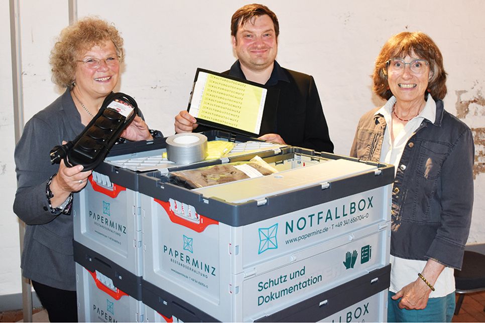 Nicolet Dittmann, ehrenamtliche Mitarbeiterin im Stadtarchiv Eutin (links), Jakob Sperrle, Stadtarchivar Eutin, und Andrea Looks, Gemeindearchivarin Scharbeutz, mit der Notfallbox.