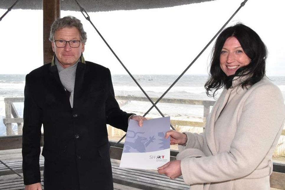 Wirtschafts- und Tourismusminister Dr. Bernd Buchholz bei der Übergabe des Förderbescheids an Bürgermeisterin Bettina Schäfer auf dem Seebrückenvorplatz in Haffkrug. (Foto: René Kleinschmidt)