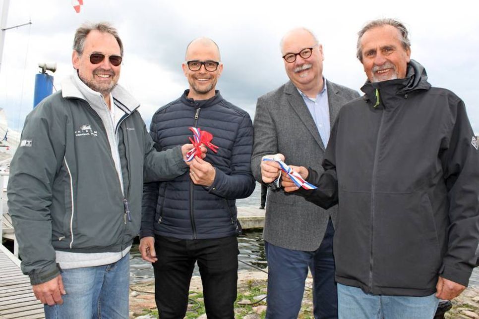 Übergabe eines Standers: Klaus Karpen (re.) und Peter Beckmann (lks.), Vorstandsspitze des Verein Schüler Segeln Schleswig-Holstein, mit Schulleiter Karsten Kilian vom Küstengymnasium (2. v. lks.) und Rolf Bohl, stellvertretender Schulleiter der Jacob-Lienau-Gemeinschaftsschule.