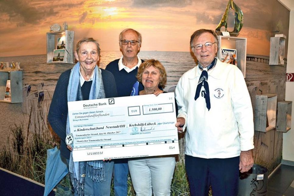 Dietrich Fritz (rechts) und Henning Rabe vom Shantychor Timmendorfer Strand überreichten den symbolischen Scheck an Mechtild Piechulla (2. v. re.) und Heidemarie Vesper. (Foto: René Kleinschmidt)