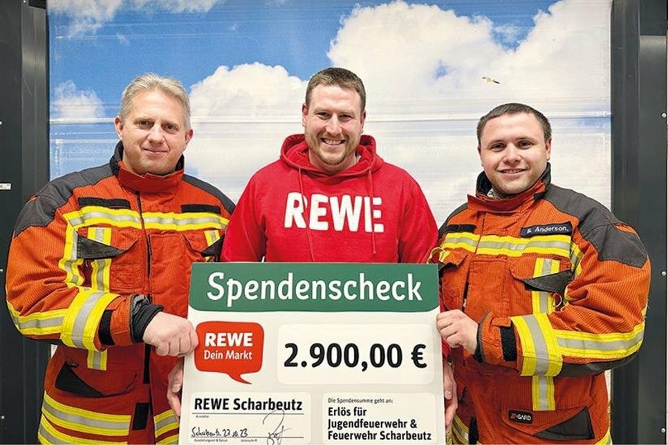 Ortswehrführer Sebastian Levgrün (von links), der stellvertretende Marktleiter Alexander Brüning und Jugendwart Bo Anderson bei der symbolischen Scheckübergabe.
