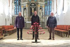 (v.l.) Hütedienstleiter Klaus Kasper, Pastor Andreas Gruben und Hüter Gerd Ernst freuen sich über den neuen Kerzenständer in der St.-Johannis-Kirche.