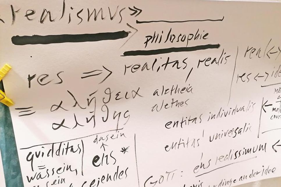 Eckdaten zur Philosophie: Plakate werden vom Kursleiter mit Pinsel gefertigt.