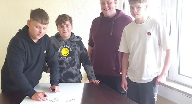 Andrej, Maurice und Olendo tragen sich auf der „Gästetafel“ ein.