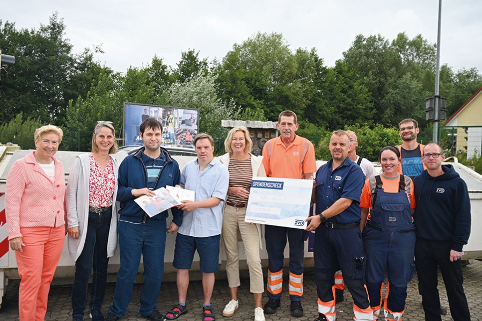 Sven Thode, Vorarbeiter auf dem ZVO Recyclinghof Bad Schwartau, und seine Kollegen bei der Übergabe der Spende an die „Villa Wir“-Delegation.