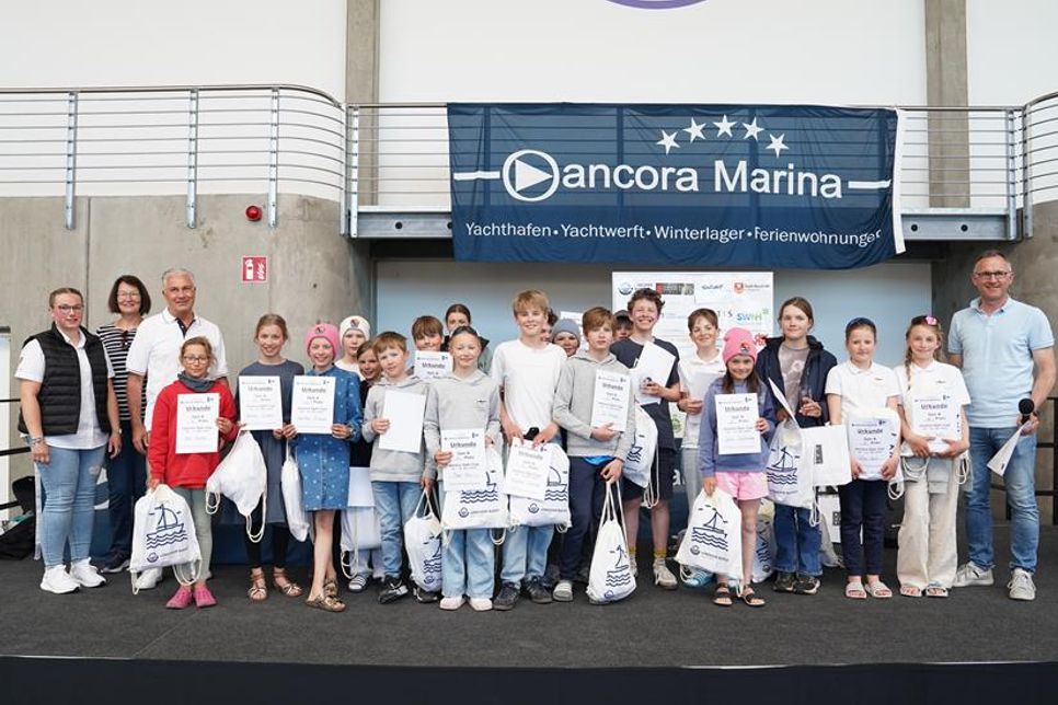 Strahlende Gesichter in der Klasse Optimist B: Die Top 20 des diesjährigen Opti Cups 2025 nahmen in der Ausstellungshalle der ancora Marina ihre Preise entgegen.
