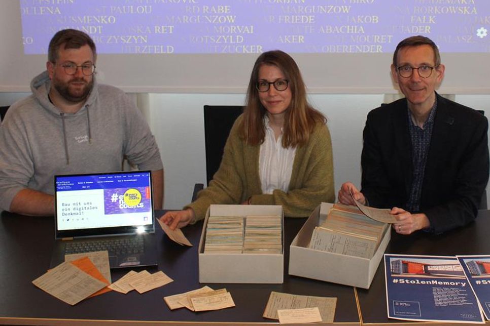 Mirco Schlippes  vom Stadtarchiv und Projektleiter des Cap-Arcona-Dokumentationszentrums sowie Julia Werner und Stefan Nies (Kuratorin/Kurator Cap-Arcona-Dokumentationszentrum) zeigen einen Teil der Bewohnerkartei des DP-Lagers in Neustadt. (Bildquelle: Stadt Neustadt in Holstein)