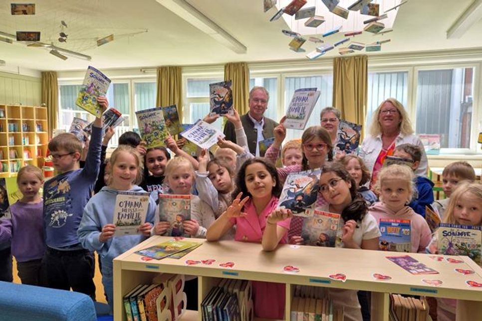 Die Klasse 1a freut sich über neue Comics - überreicht von Rüdiger Nittritz (Rotary-Club), Susanne Müller (Bücherhafen) und Schulleiterin Antje Sagawe (hinten v. lks.).
