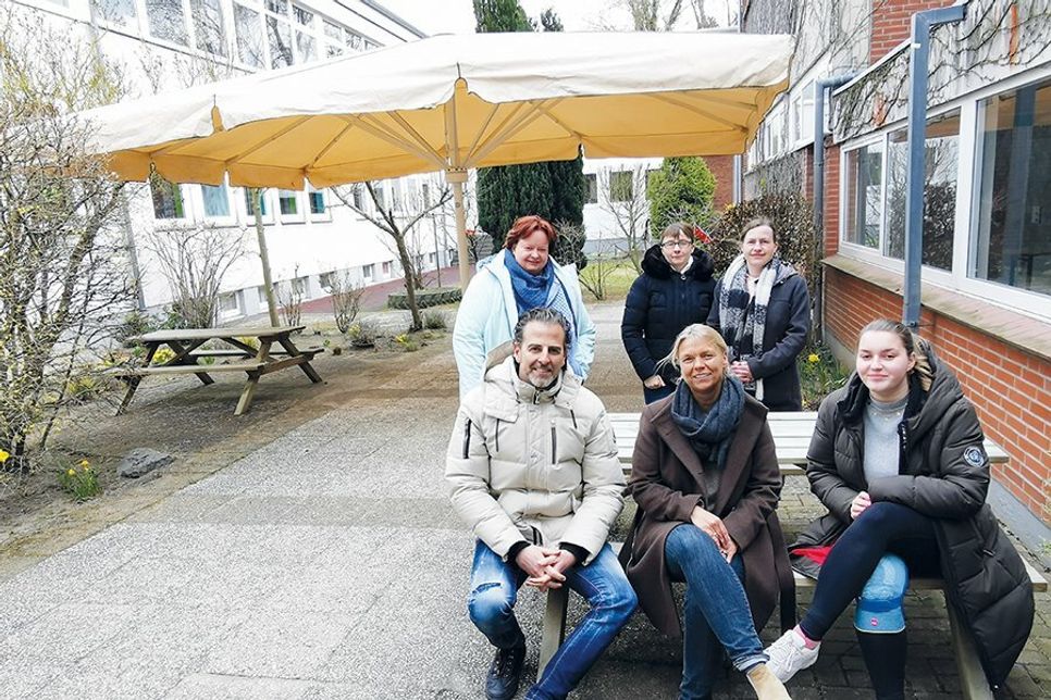 Die Mitglieder des Arbeitskreises „Sonnensegel“ mit Sponsor Jan Schumann vor dem XXL-Schirm im Innenhof der GGS-Strand Europaschule.