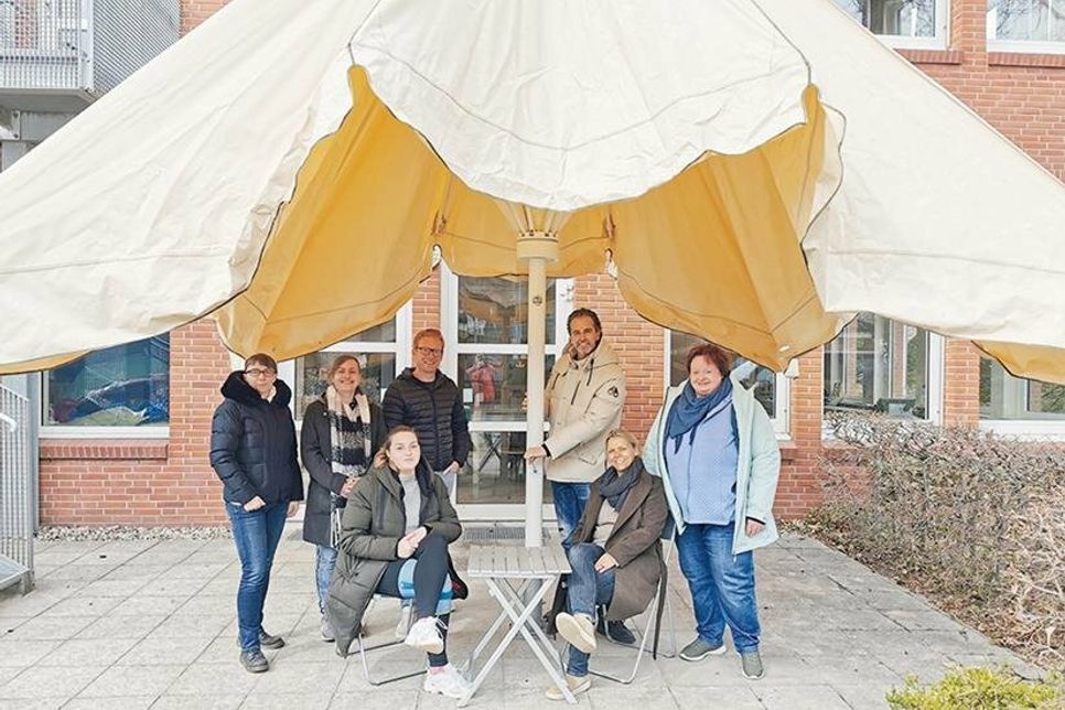 Die Elternvertreterinnen Marion Vits und Sabine Zabke, Schülersprecherin Lilian Haselow, Jan Fiergolla, Jan Schumann, Schulleiterin Esther Passig und Grundschulkoordinatorin Julia Christiansen beim Aufdrehen des Schirmes.
