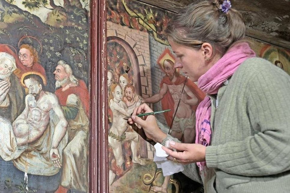 Isa von Lenthe retouchiert mit feinem Pinselstrich schadhafte Bereiche der Malerei aus barocker Zeit.