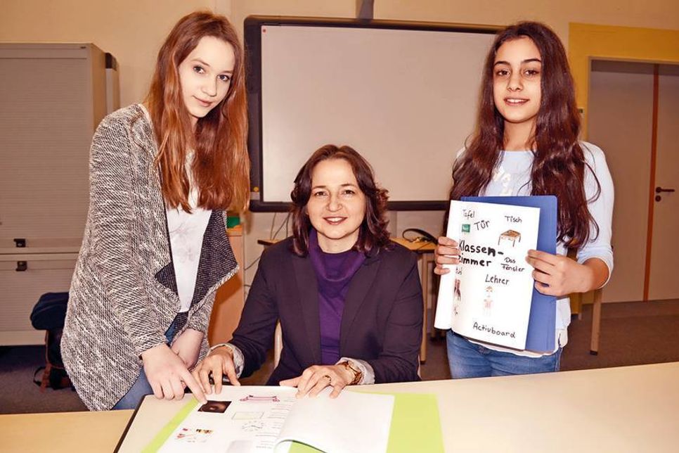 Vanessa (links) und Viviana zeigen Bürgermeisterin Hatice Kara das frisch hergestellte Bildwörterbuch. (Fotos: René Kleinschmidt)