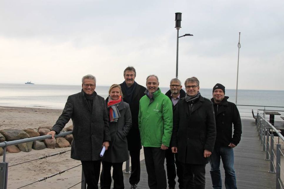 Volker Owerien, Dr. Silke Katharina Berger, Dr. Lothar Oelert, Helmut Grawe, Ralf Liedke, Dietmar Schindowski und Peer Langemak (v. lks.) freuen sich erstmalig solch ein innovatives und energieeffizientes Versuchsprojekt (im Hintergrund) in Scharbeutz umsetzen zu können.