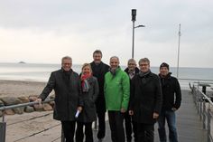 Volker Owerien, Dr. Silke Katharina Berger, Dr. Lothar Oelert, Helmut Grawe, Ralf Liedke, Dietmar Schindowski und Peer Langemak (v. lks.) freuen sich erstmalig solch ein innovatives und energieeffizientes Versuchsprojekt (im Hintergrund) in Scharbeutz umsetzen zu können.